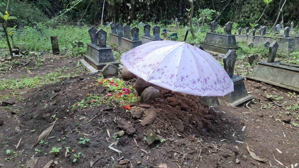 Dina父親在她的墓地架起一把紫色的雨傘。（相片由工權會提供）