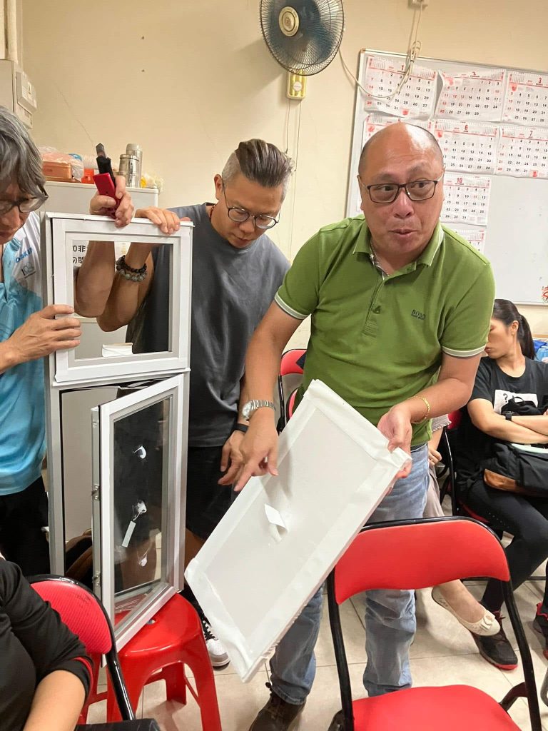 宏福苑維修工程項目經理何生(綠衣)聯同工程監督向新一屆管委會成員講解工程人員會將發泡膠板貼窗。(資料來源:宏福苑法團網頁)