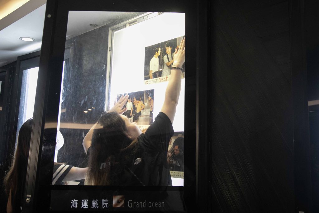 海運最後一天放映日，安排李小龍電影作結，工作人員急急換燈箱海報。（關震海攝）