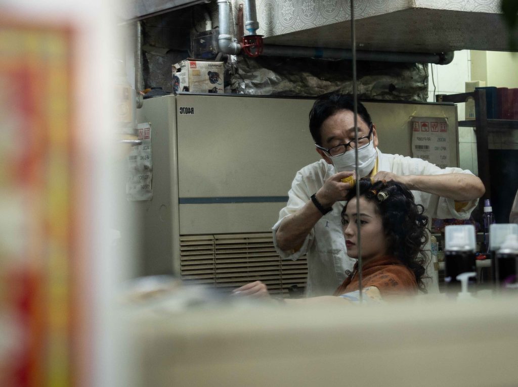 小紅書流行「港風」，吸引遊客慕名而來體驗港式「恤髮」，圖中顏師傅示範拿手「魔鬼妝」。（林永聰攝）