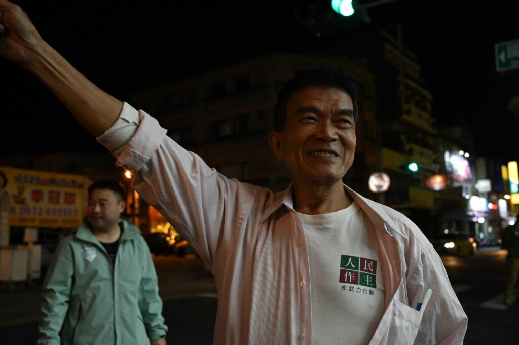 綠營支持者向記者展示他身穿的T-shirt「人民作主 非武力行動」。(劉彥汶攝)