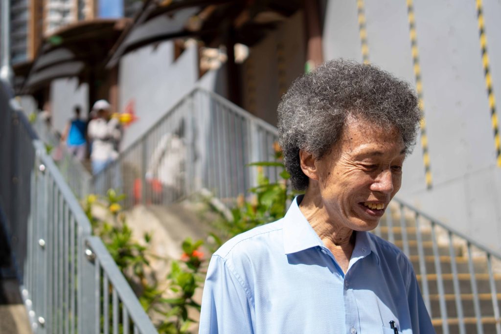 繼炳站在爭取了數十年的百步梯升降機旁,笑言長者鄰舍中心是他人生的最後一個任務。(林永聰攝)