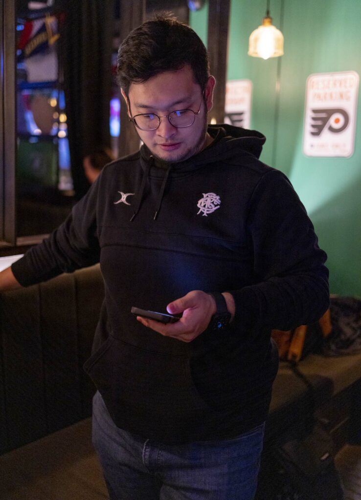 活動發起人Sam 一邊看開票，一邊跟台灣的親朋戚友沒聯絡，討論選舉開票進程。（Hesther Ng 攝）