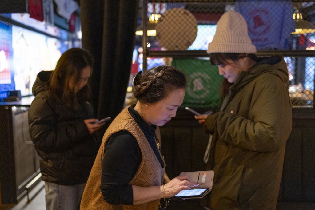 參與開票聚會的台灣人在開票結果公布後都紛紛用手機與在台的家人和朋友們聯絡。（Hesther Ng 攝）